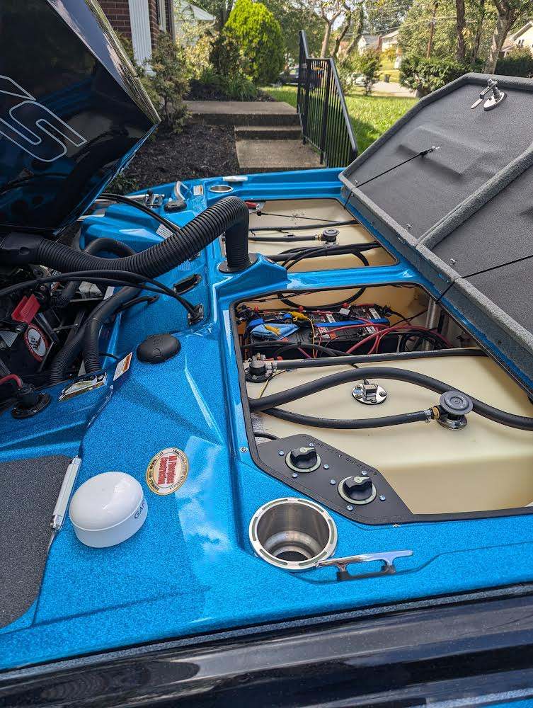 Bass Cat Puma Caracal Double Battery Switch bracket visible in a blue boat compartment beside wiring and rotary switches.