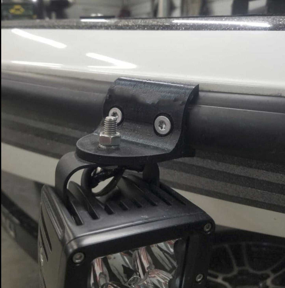 Rub Rail Headlight Mount black weather-resistant bracket securing a square LED light fixture to a boat rub rail