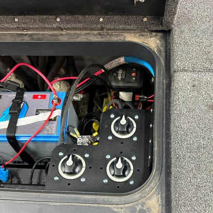 Skeeter 3-in-1 Battery Switch bracket, matte black metal mount holding three rotary battery switches beside a battery