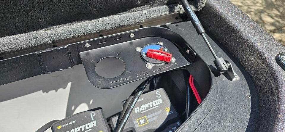 Skeeter dual battery switch bracket in matte black metal, mounted with a red rotary switch and one open switch cutout