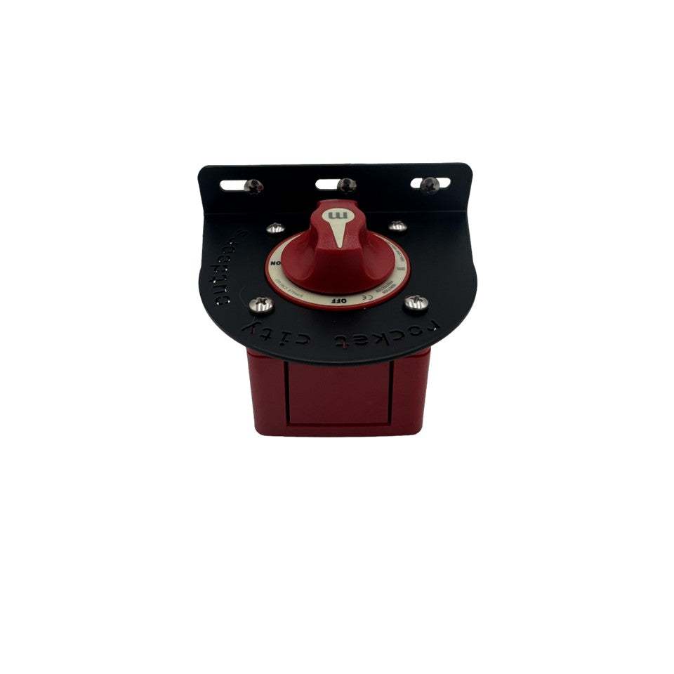 Universal battery switch mounting bracket in matte black aluminum, shown fitted with a red rotary battery switch and silver hardware.