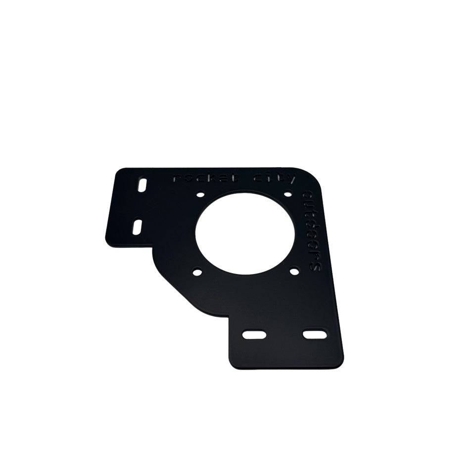 Xpress Battery Switch Corner Bracket in matte black coated metal with a large circular switch opening and mounting slots