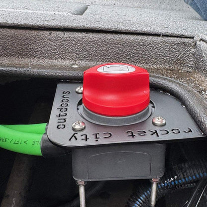 Xpress Battery Switch Corner Bracket, black metal mounting plate fitted with a red rotary battery switch