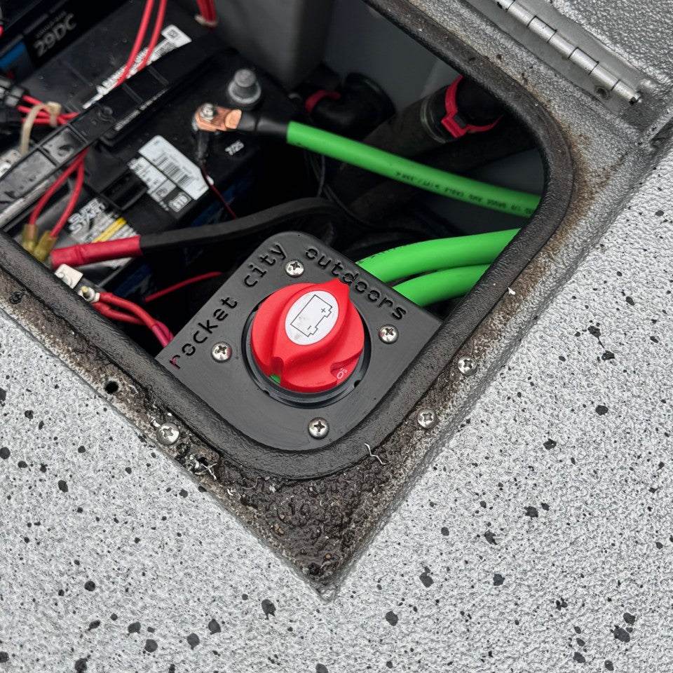 Xpress Battery Switch Corner Bracket, matte black corner mount holding a red battery switch among boat wiring