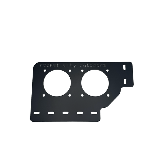 Xpress Dual Battery Switch Bracket, a matte black aluminum mounting plate with two large circular cutouts and slots